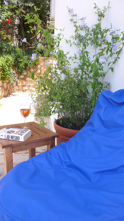 Bean bag seating in shade with flowering plumbago on private terrace