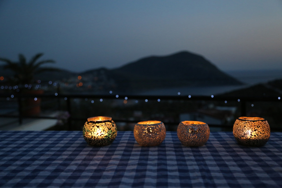 Candles glowing, view of bay at sunset